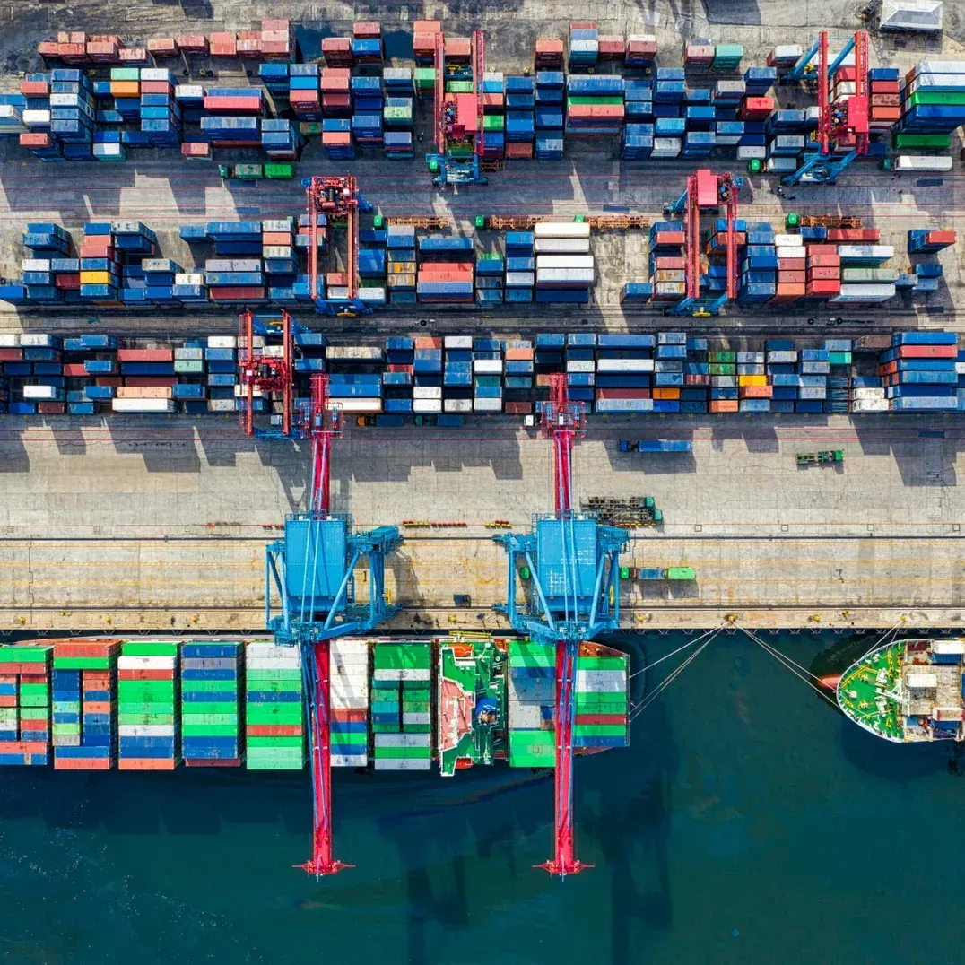 Aerial view of shipping containers at a port, representing global supply chain operations and smart, scalable, and data-driven FMCG supply chain management