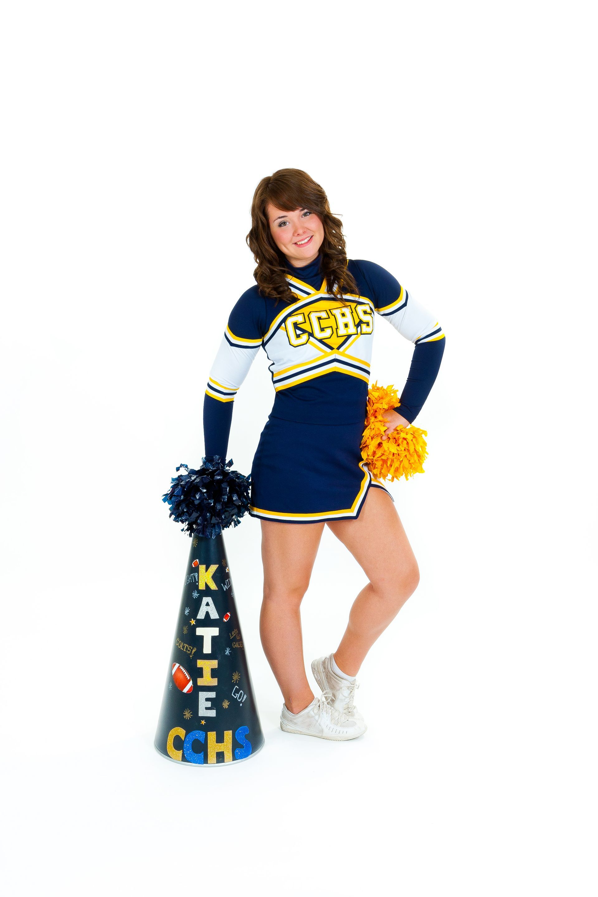 Cheerleader in navy, white, and yellow uniform holding pom-poms beside a blue megaphone with “KATE” on it