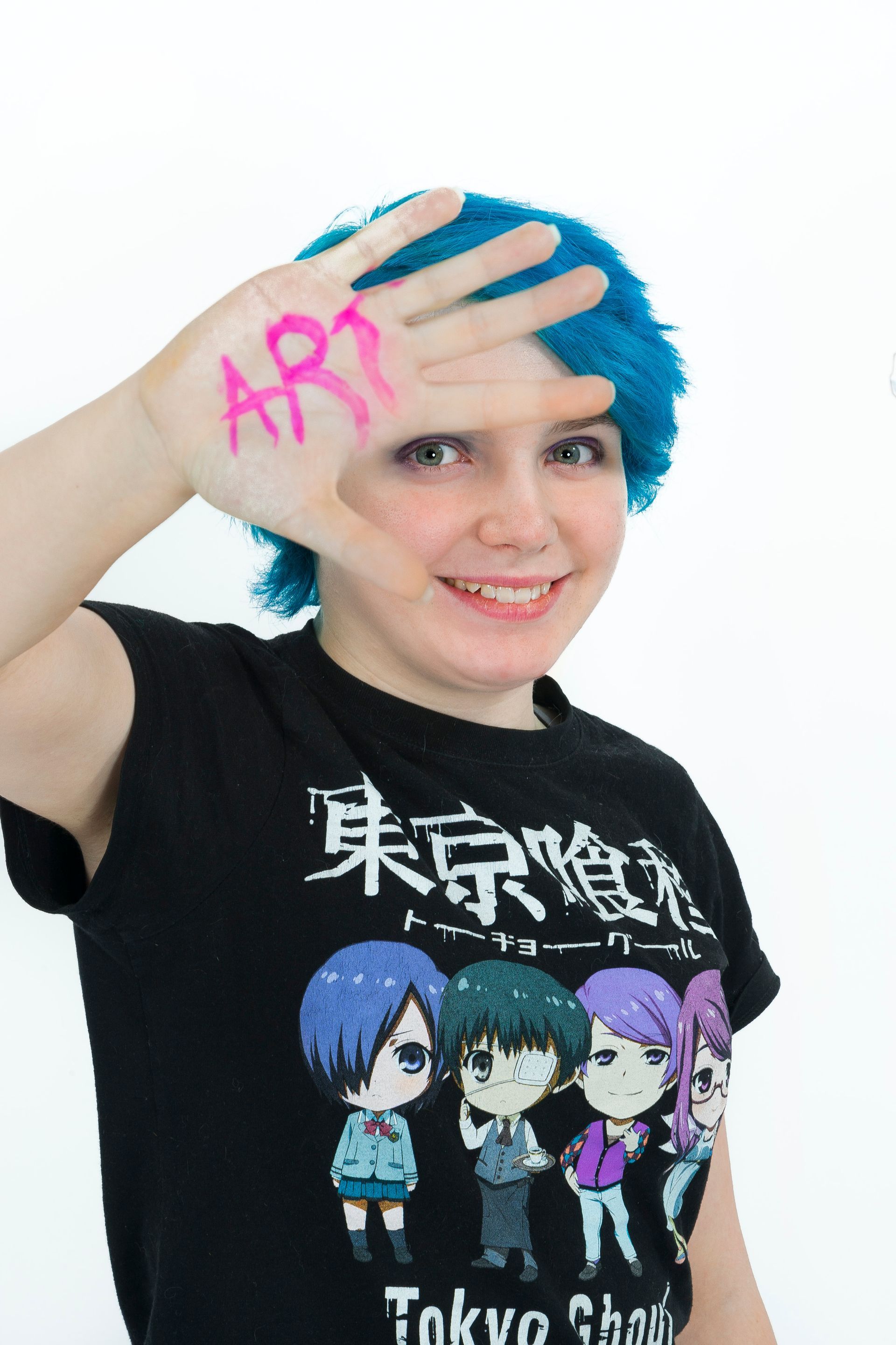 Person with blue hair smiling, hand raised to forehead with pink