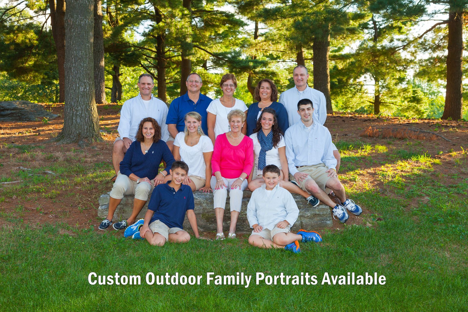 Large family group posing outdoors in a wooded park, with “Custom Outdoor Family Portraits Available” text.