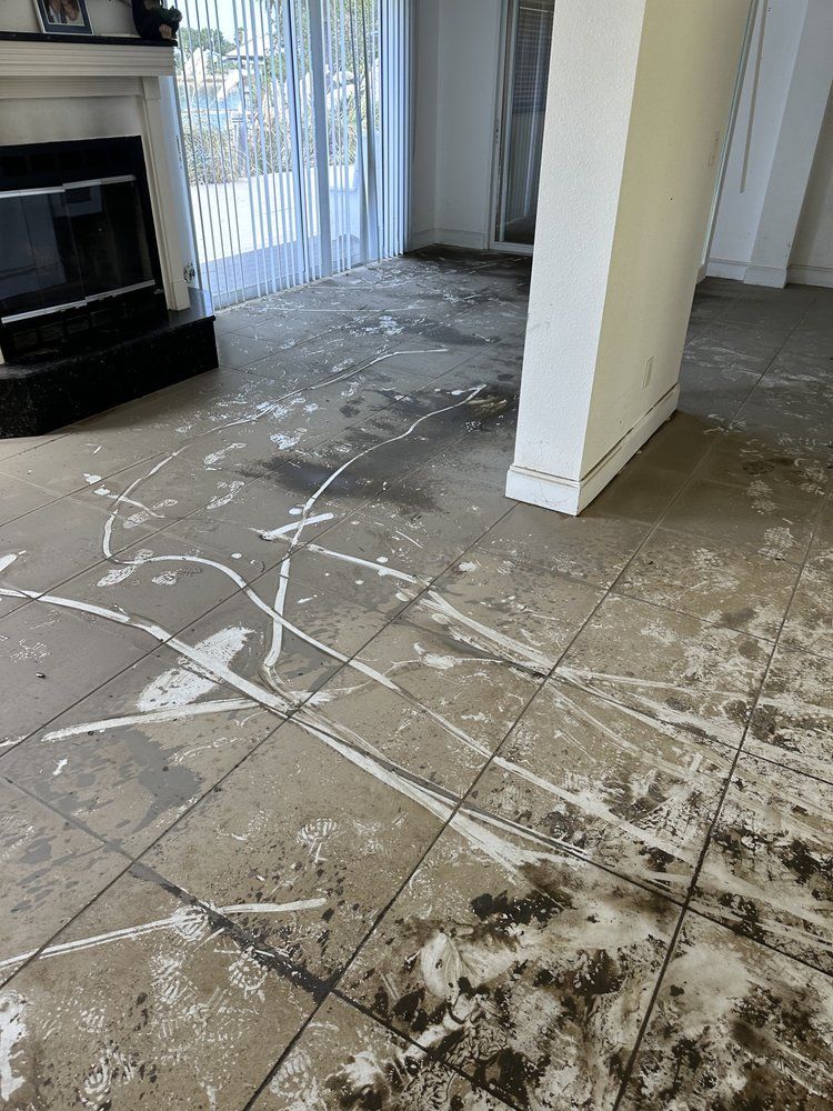 a living room with a dirty tile floor and a fireplace