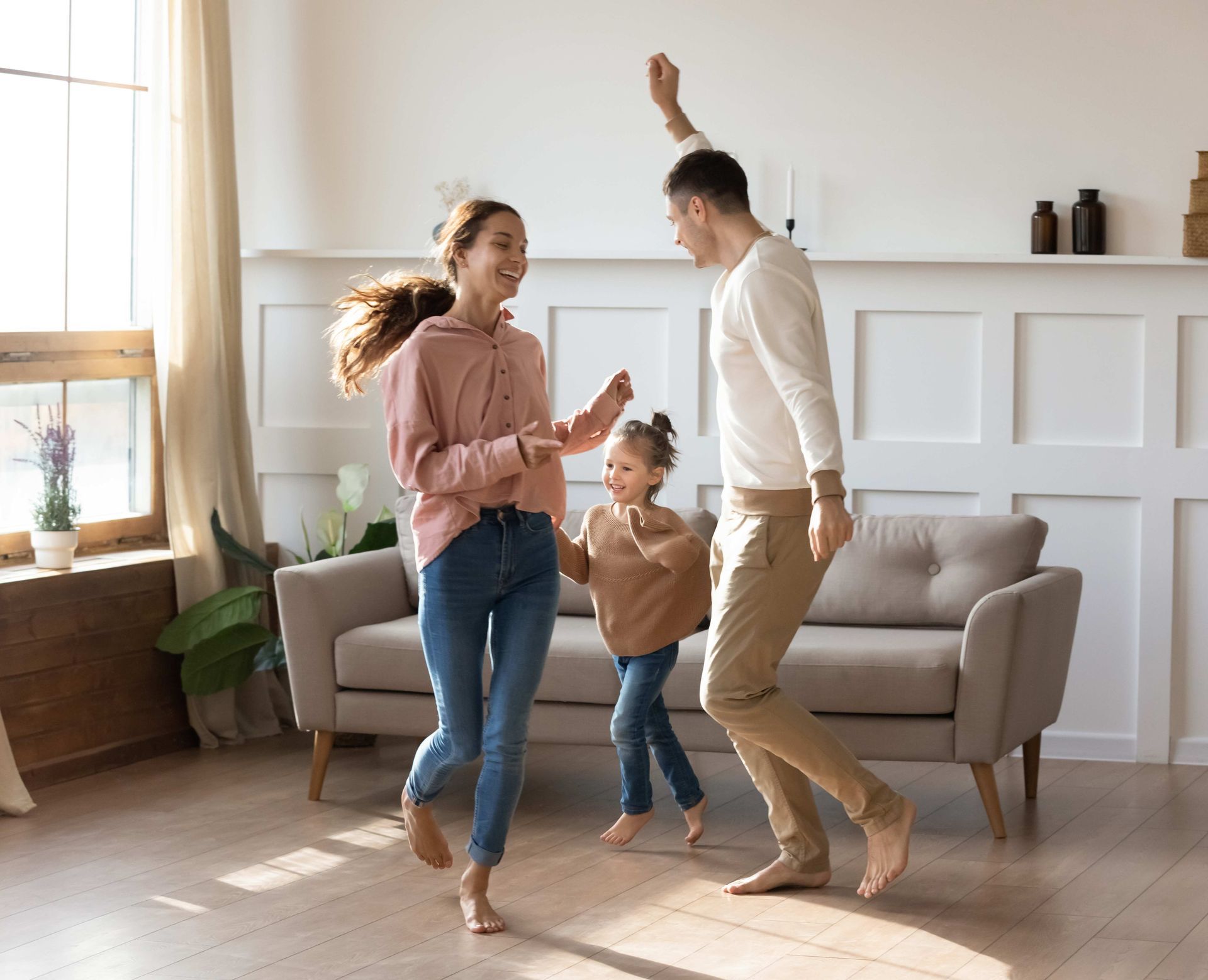 a family is dancing together in a living room