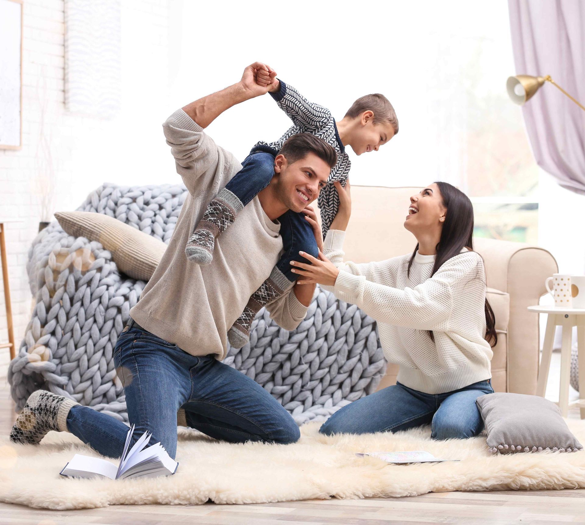 a man is carrying a child on his shoulders in a living room