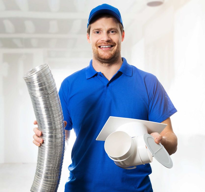 A man in a blue shirt is holding a hose and a fan