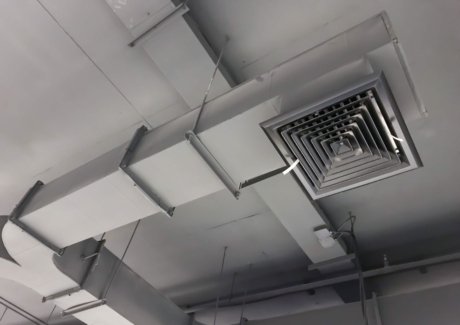 there are a lot of ducts hanging from the ceiling of a building