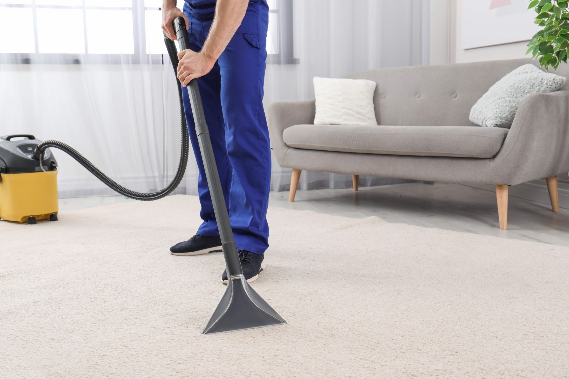 a man is using a vacuum cleaner to clean a carpet in a living room