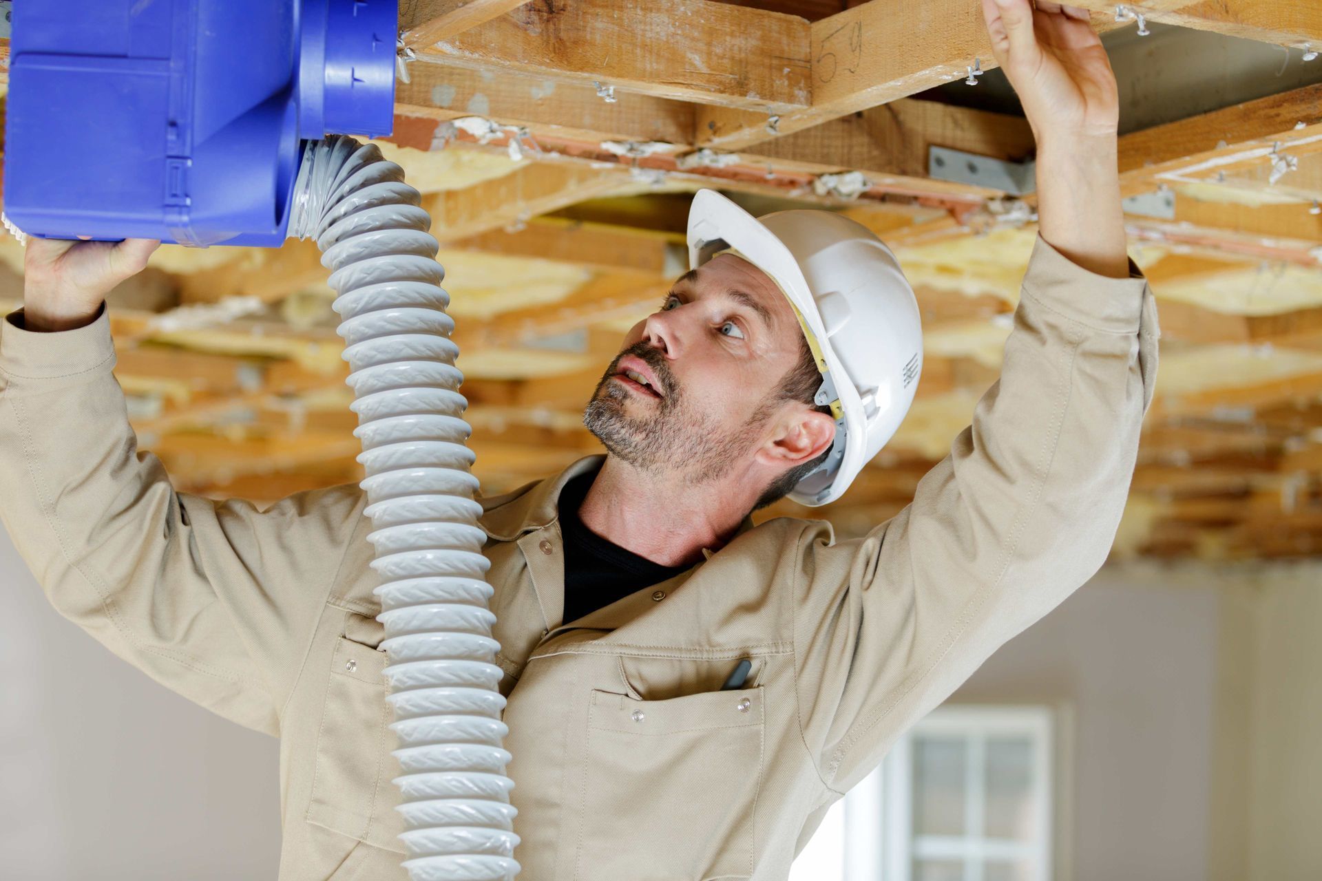 a man is working on the ceiling of a house