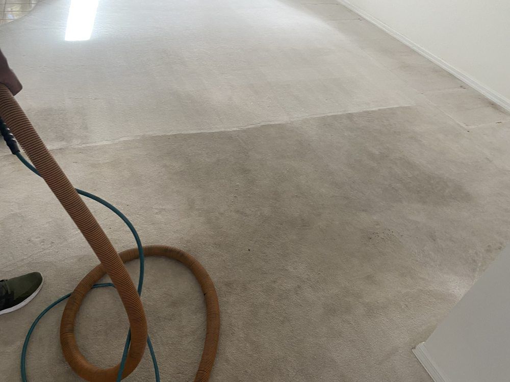 A vacuum cleaner is being used to clean a carpet in a room.