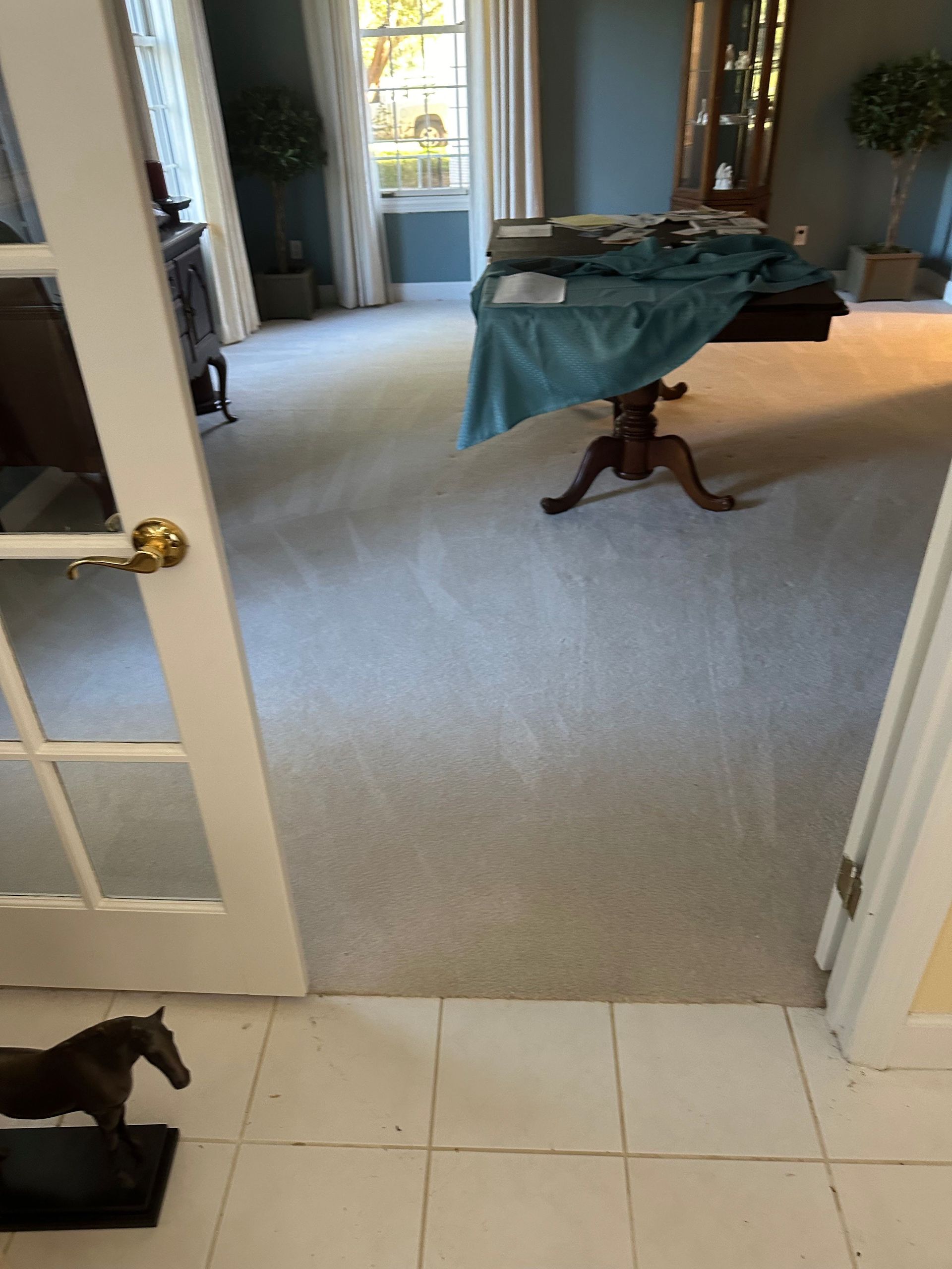 a living room with a table and a statue of a horse on the floor