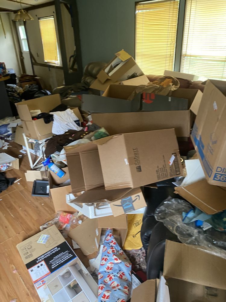 A living room filled with lots of cardboard boxes and trash.