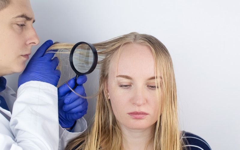 Doctor analizando la perdida de cabello en una mujer