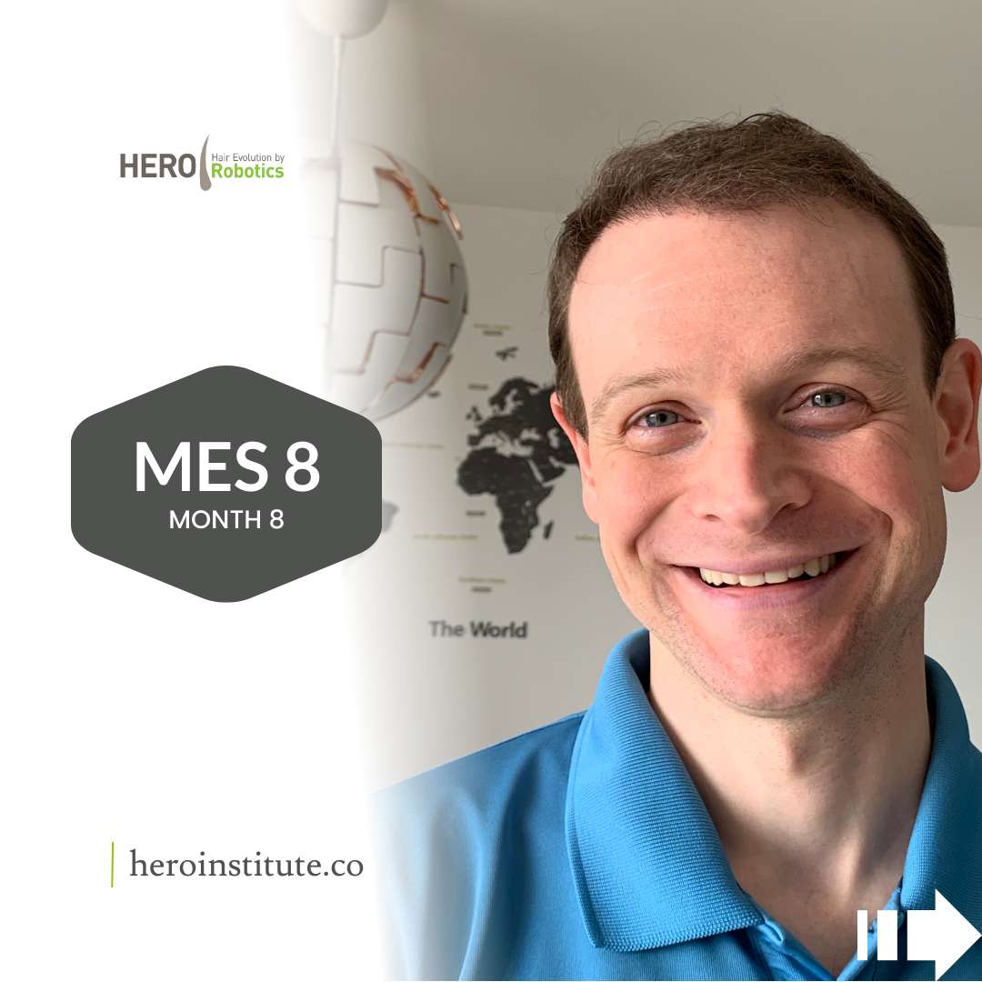 a man in a blue shirt is smiling in front of a map of the world