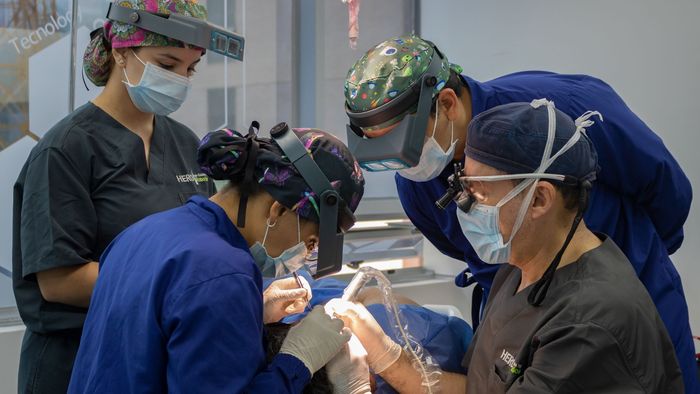 Un grupo de cirujanos está trabajando en un paciente en un hero institute.