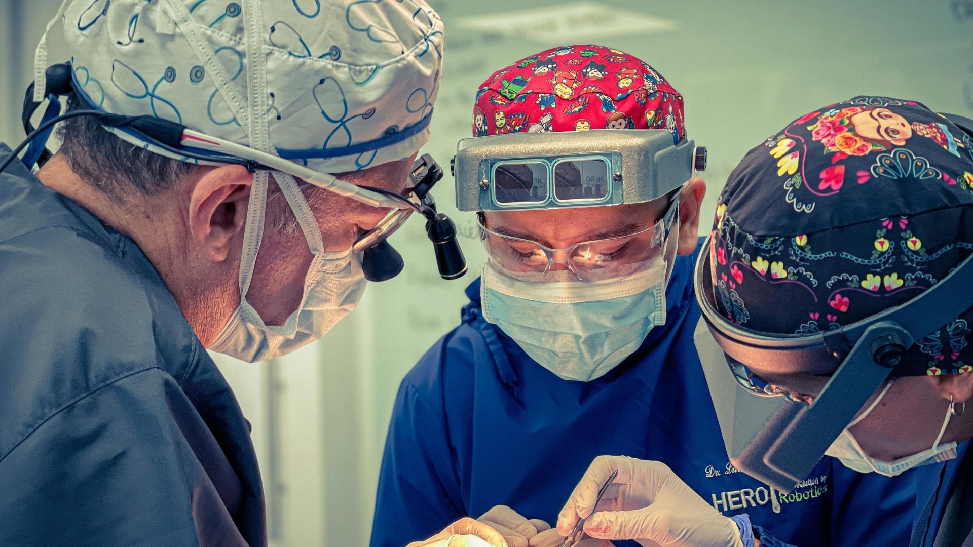 A group of HERO Institute surgeons are operating on a patient in an operating room.