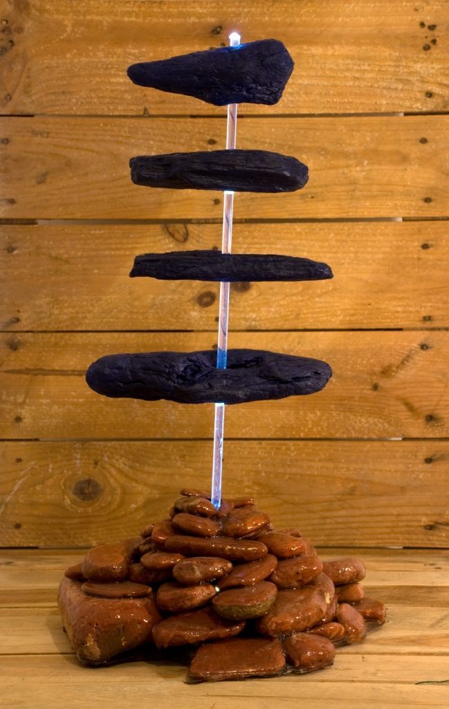 Uma escultura de pedras empilhadas umas sobre as outras sobre uma mesa de madeira.