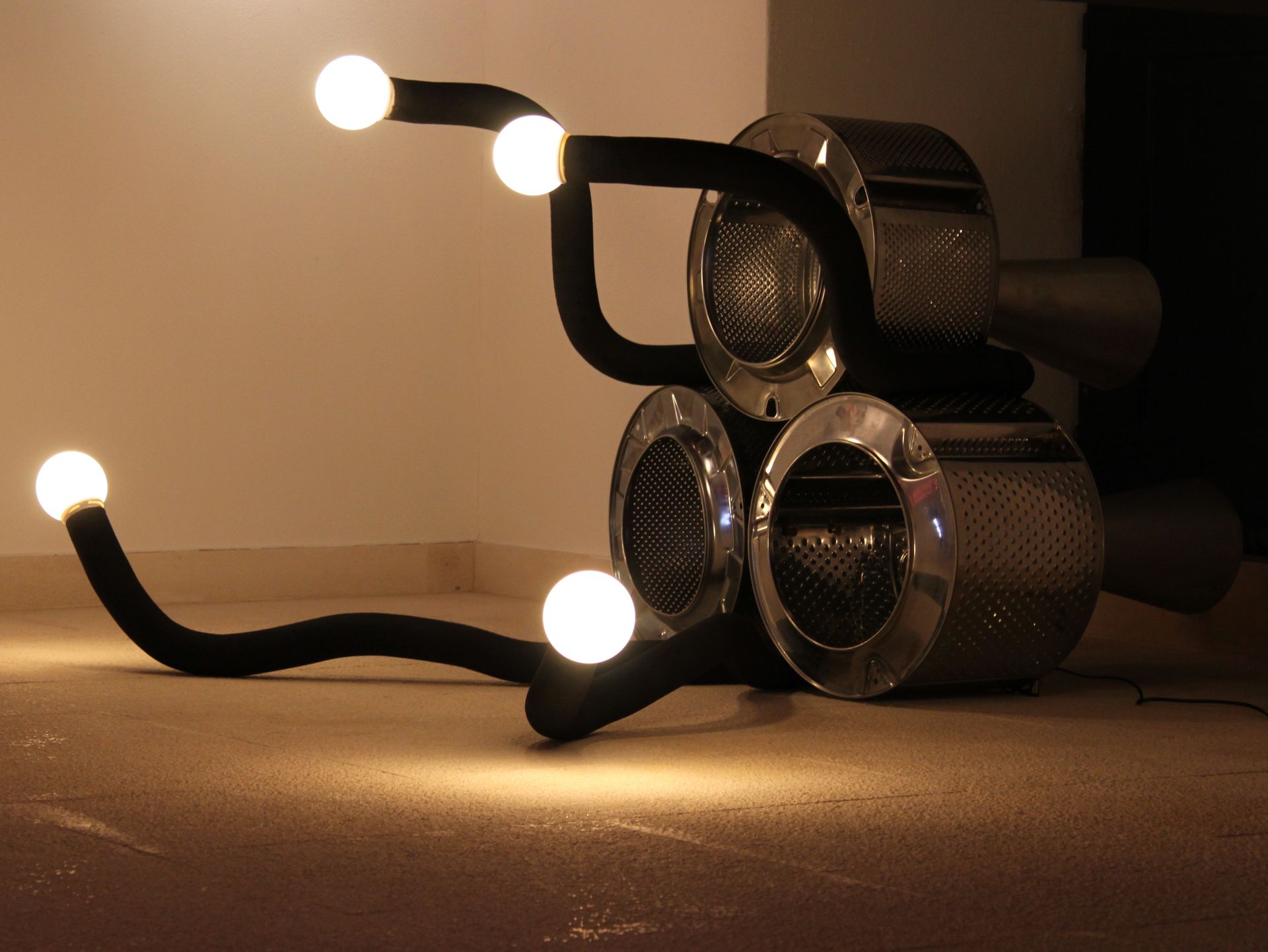 Uma lâmpada feita de um tambor de máquina de lavar é acesa