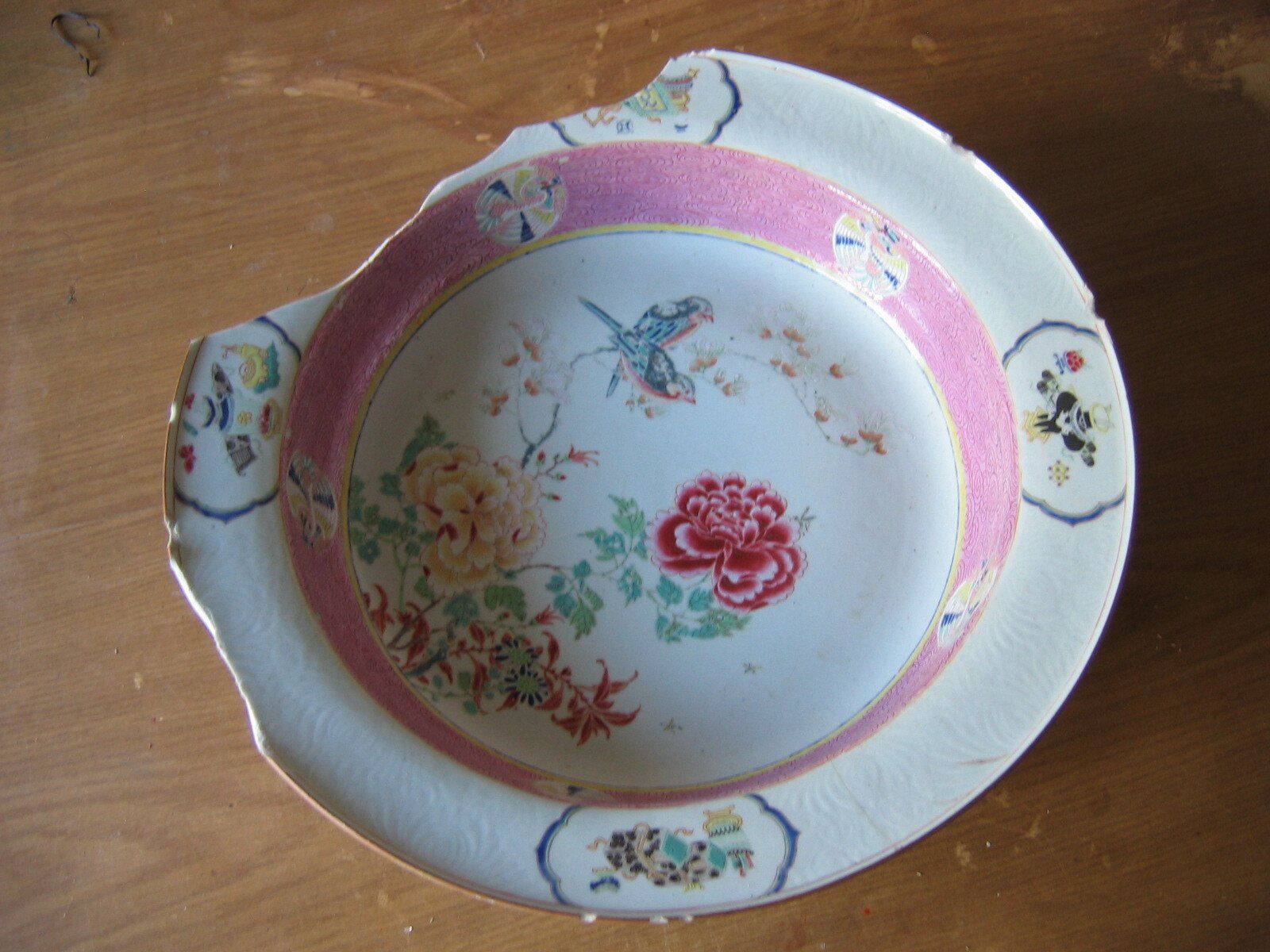 Um prato branco com uma borda rosa e flores nele