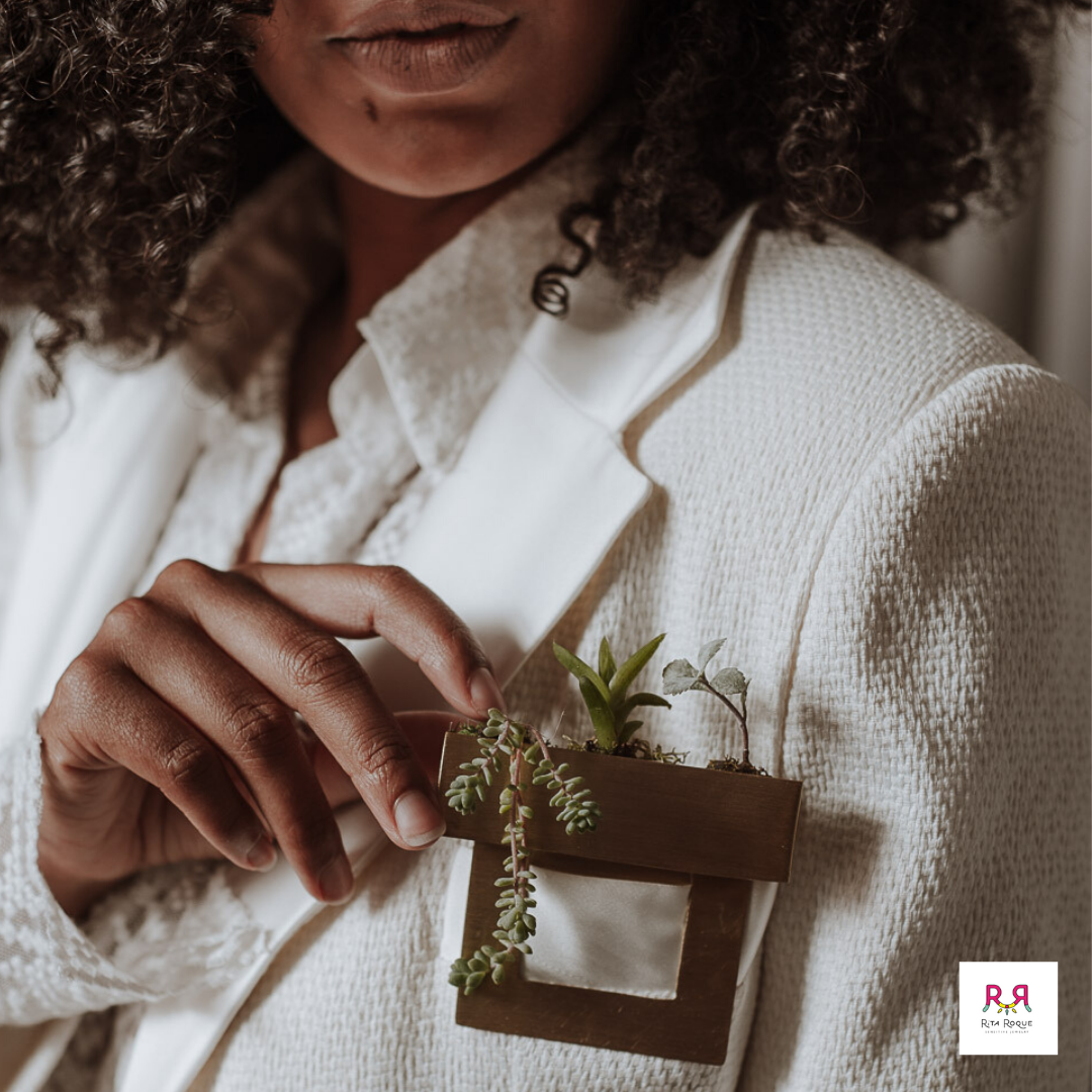 Uma mulher vestindo uma jaqueta branca tem uma planta no bolso
