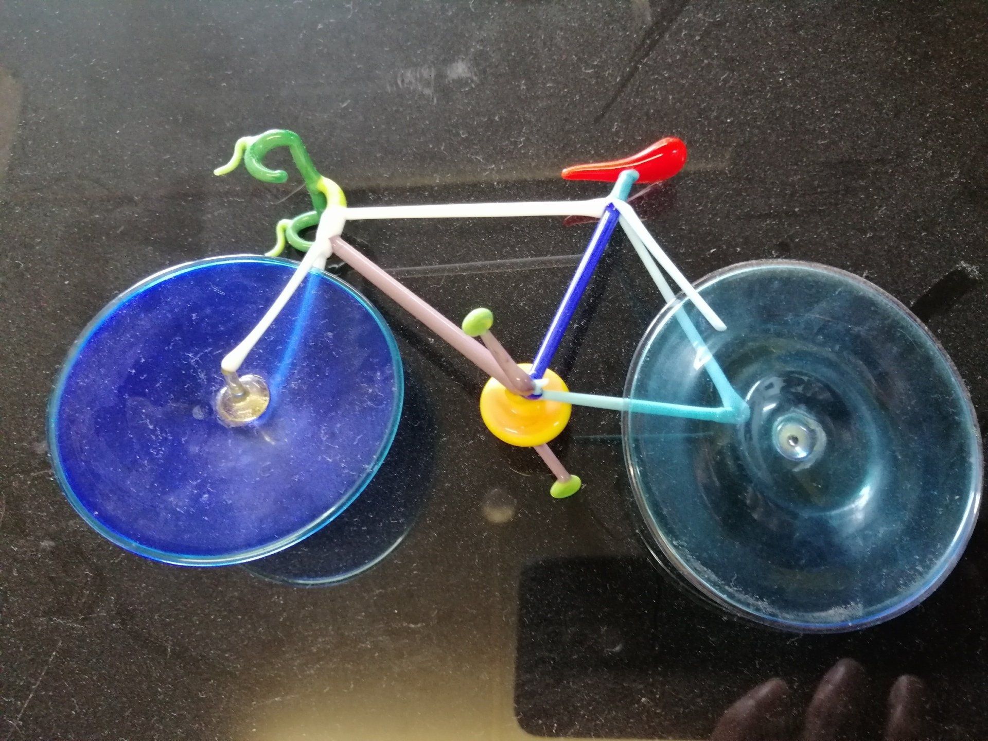Uma bicicleta feita de limpadores de cachimbo está sobre uma mesa