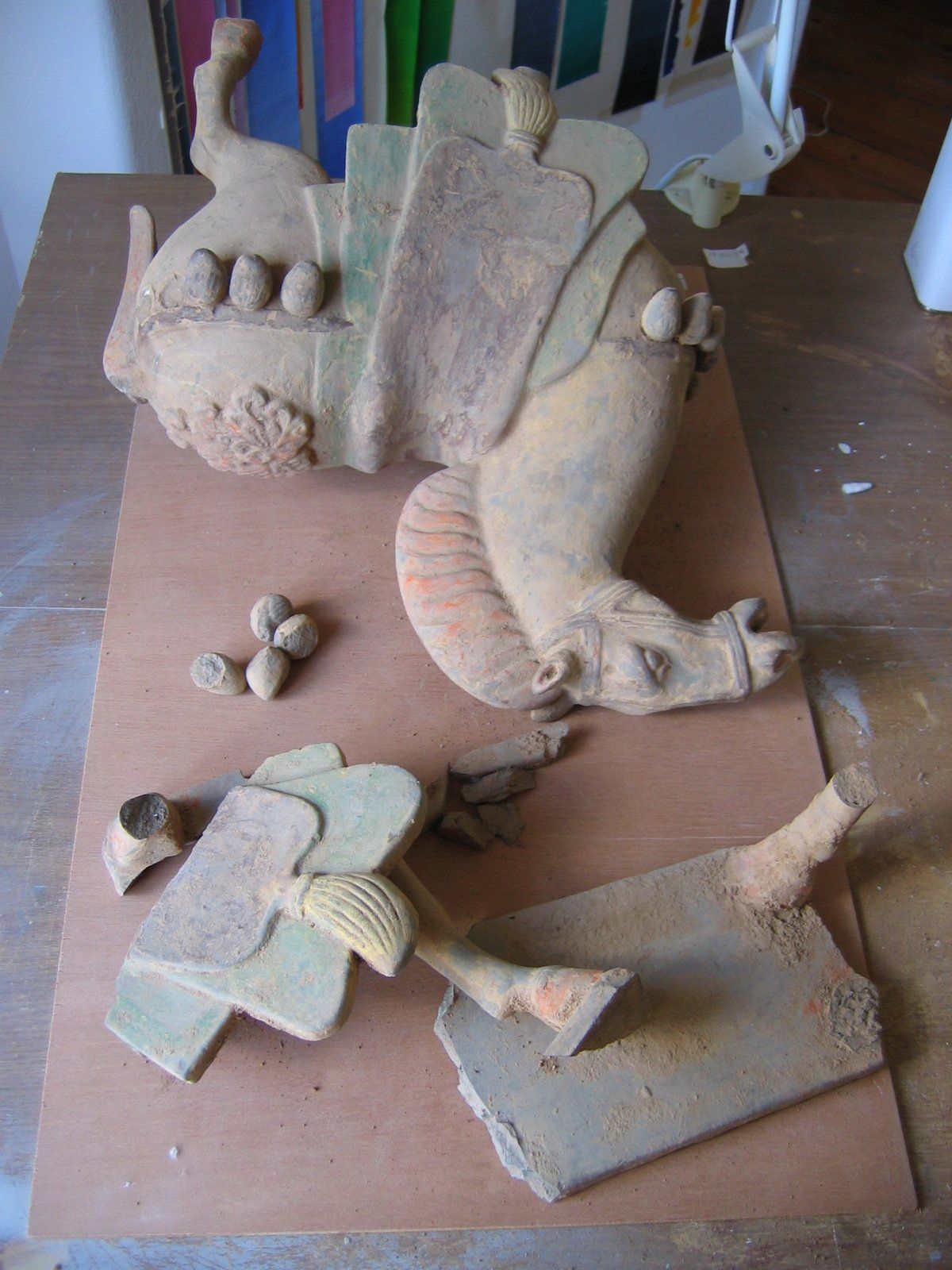 Uma escultura de argila de um dragão está sobre uma mesa de madeira