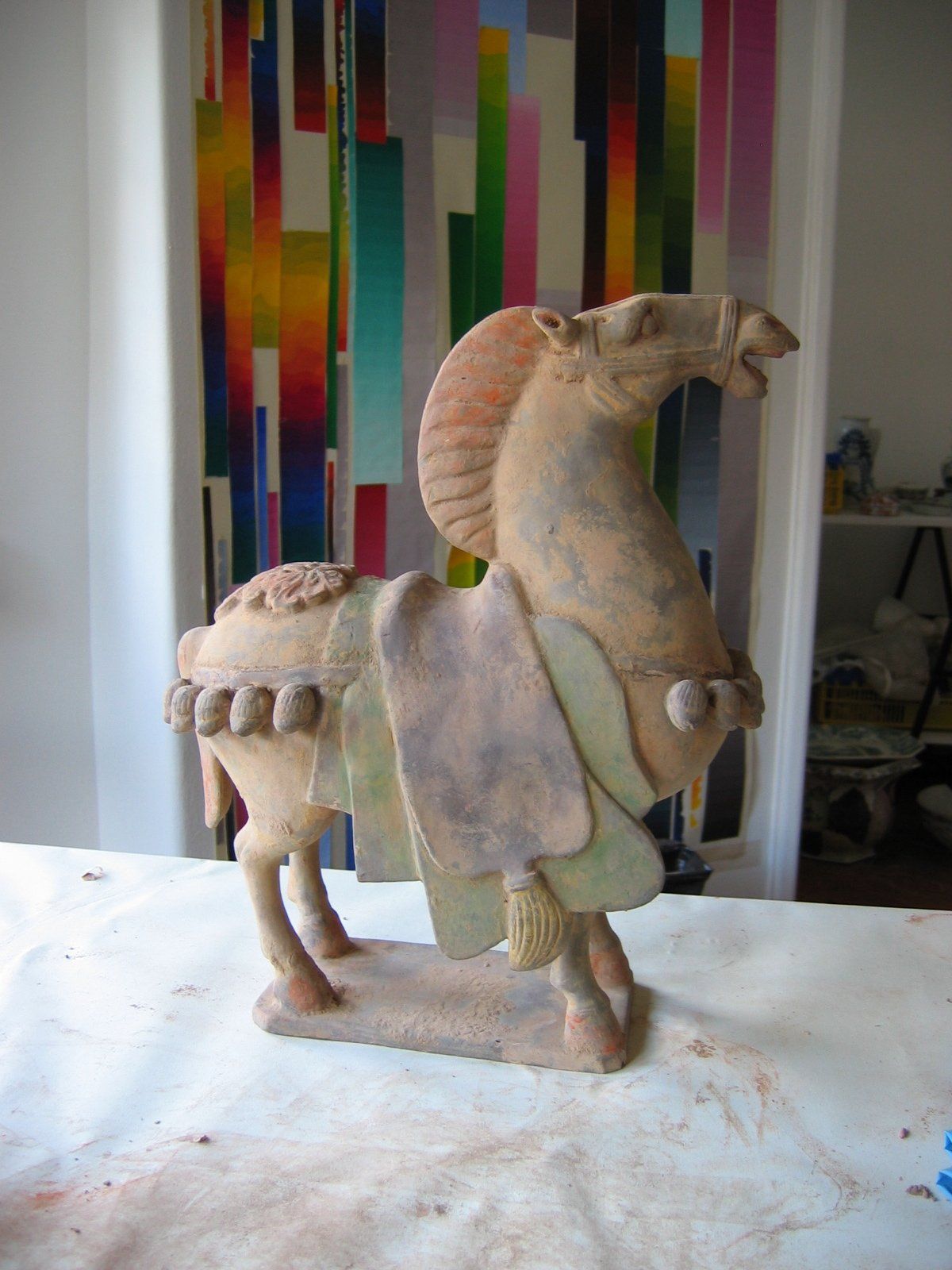 Uma estátua de um cavalo com uma sela sobre uma mesa
