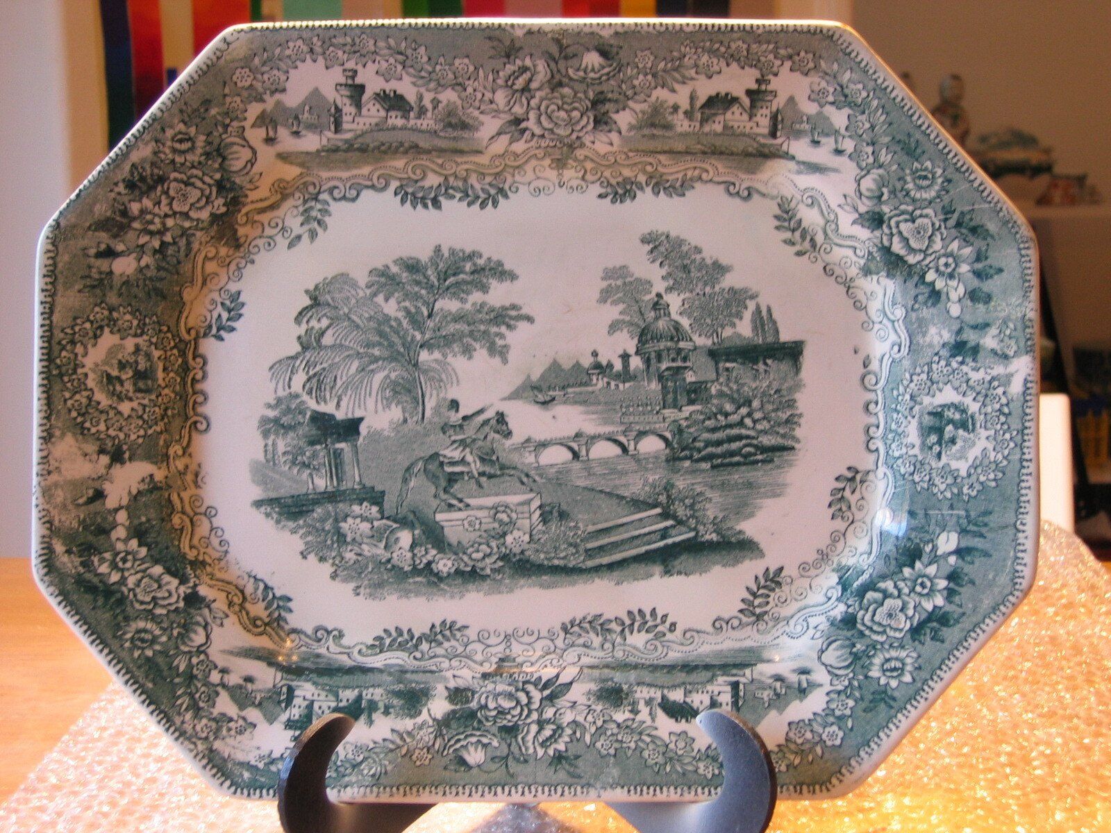 Um prato verde e branco com uma paisagem nele