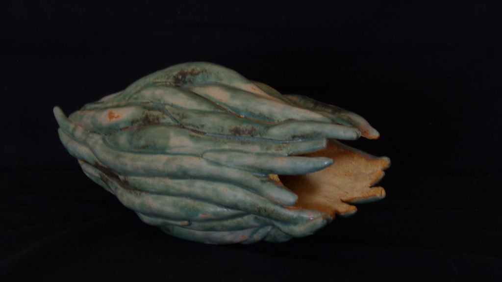 Um close de uma estátua de uma mão em um fundo preto.