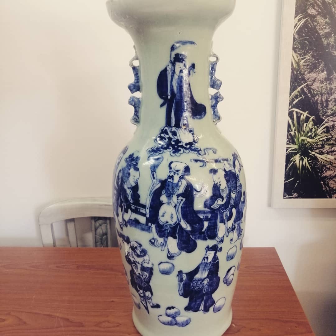 um vaso azul e branco sobre uma mesa de madeira