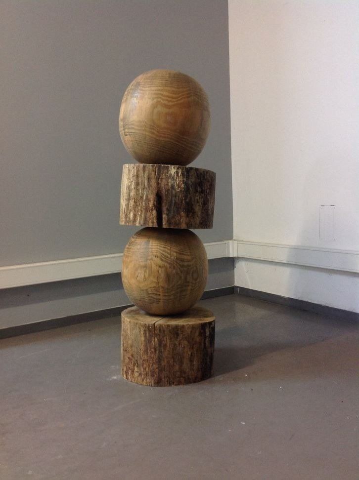 Uma escultura de madeira empilhada uma sobre a outra em uma sala.