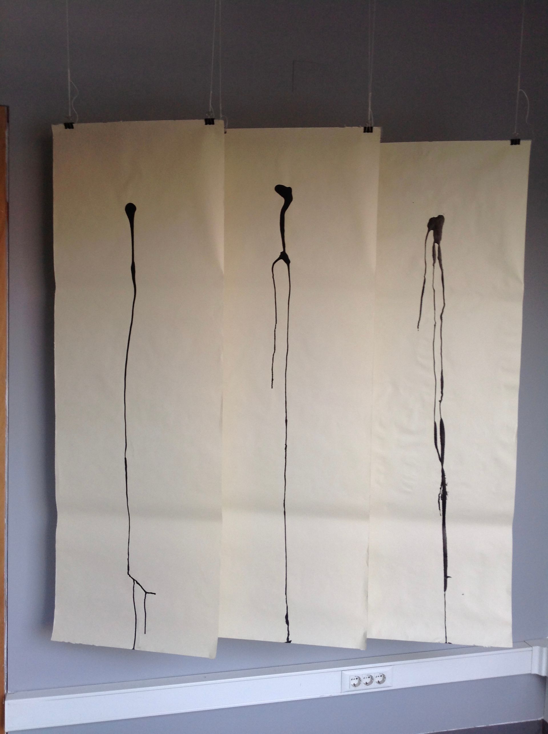 Três pedaços de papel estão pendurados na parede e um deles tem o número 222