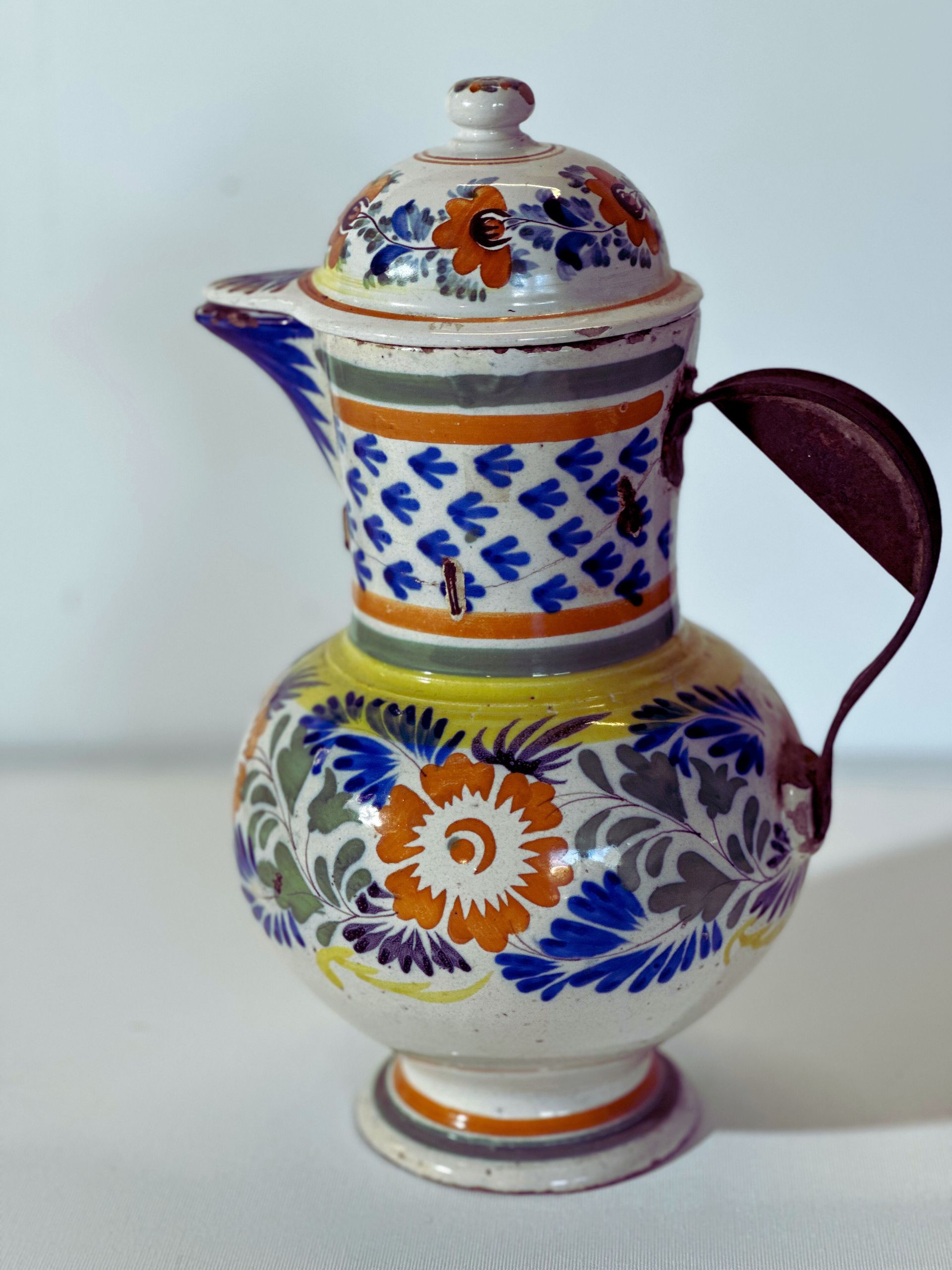 A ceramic pitcher with a floral design on it