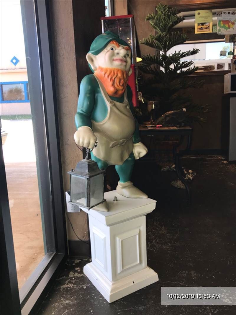 A statue of a leprechaun holding a lantern