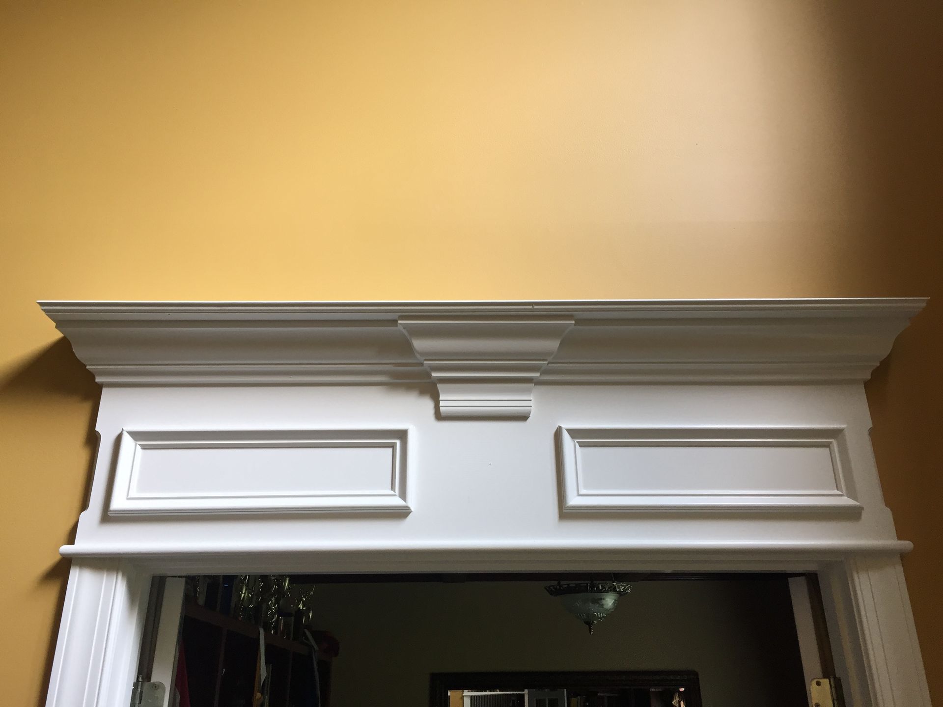 A doorway with a white trim and a yellow wall