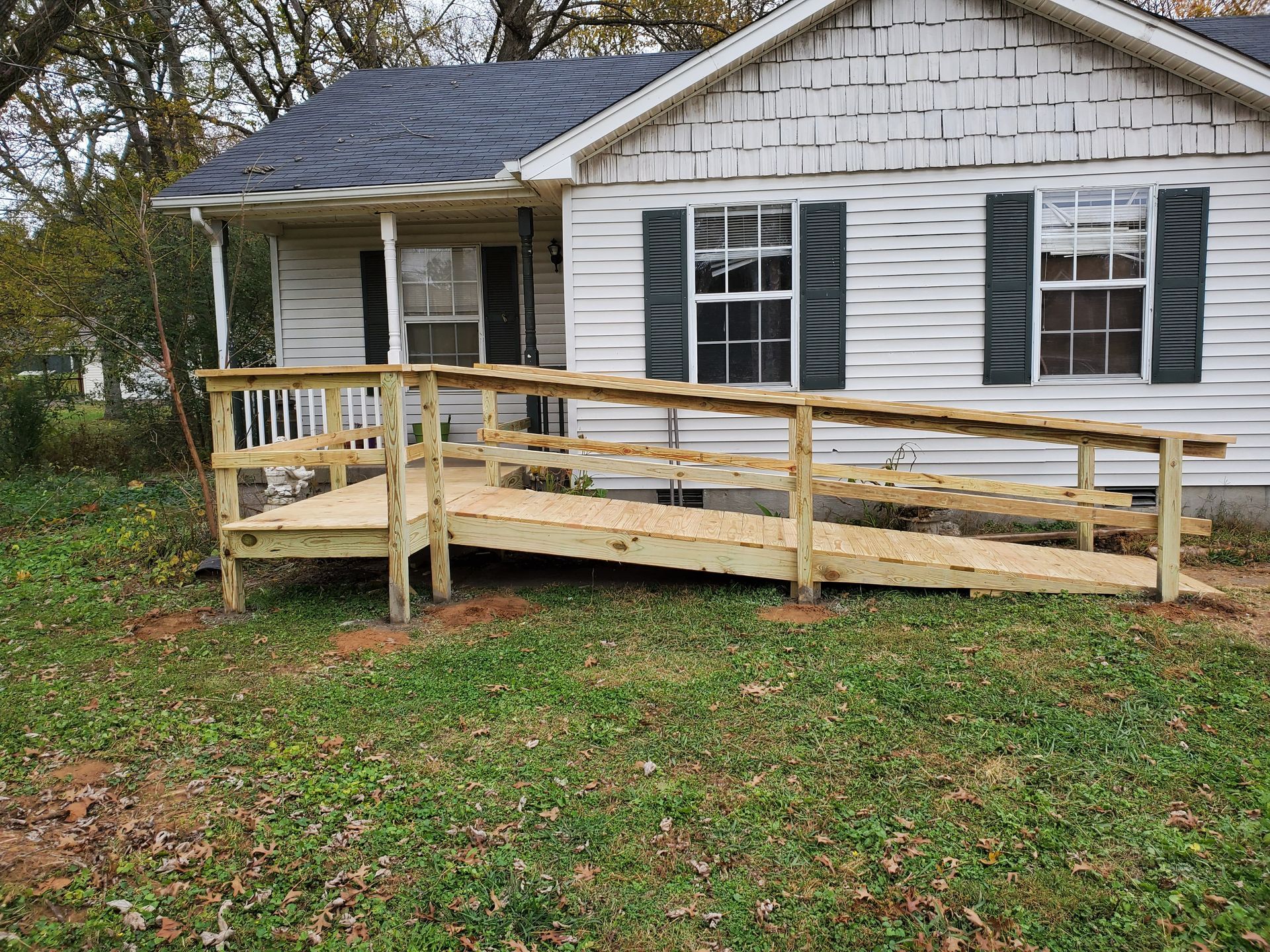 A white house with a wooden ramp in front of it.