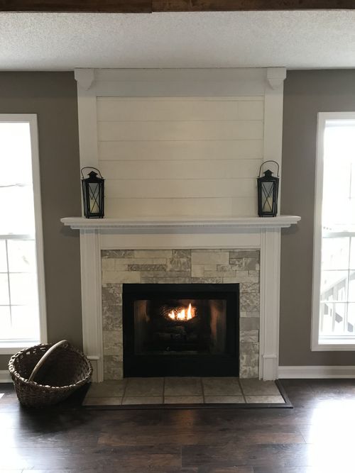A living room with a fireplace and a basket on the floor