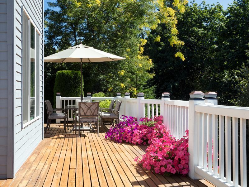 A deck with a table and chairs and an umbrella