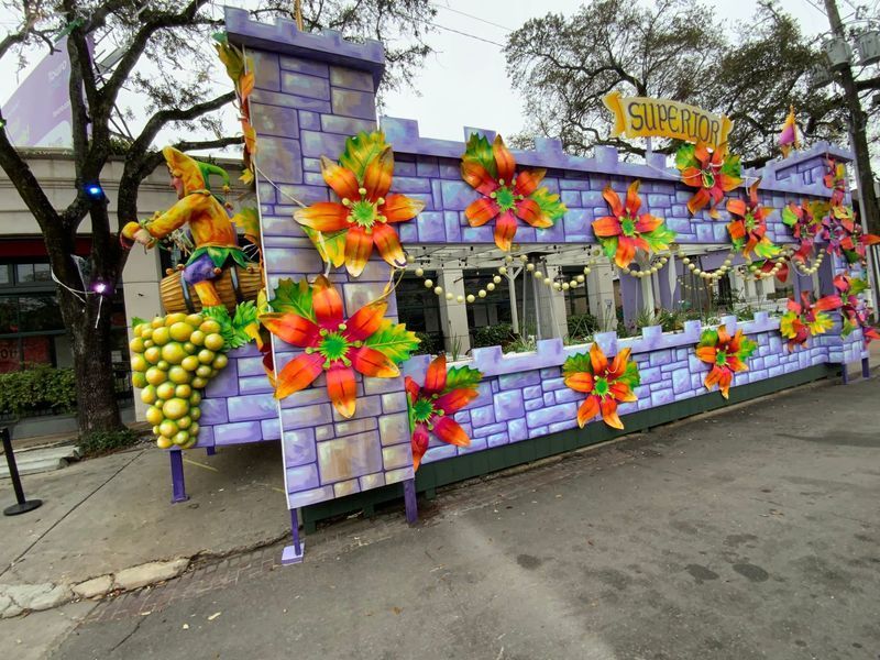 Mardi Gras float with a purple castle design, decorated with orange flowers and grapes;