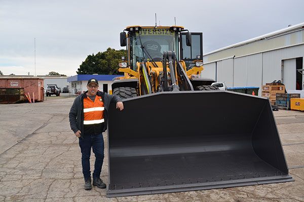 Loader operator standing by Volvo loader