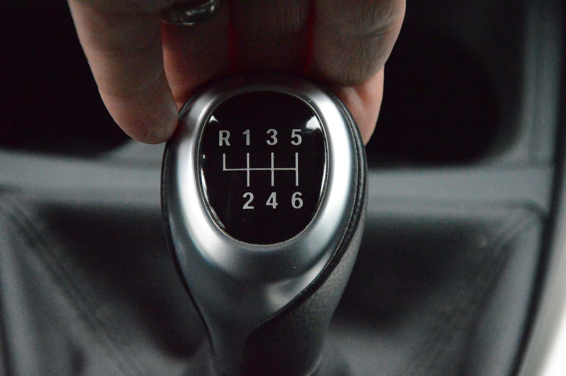 A close up of a person holding a car gear shift