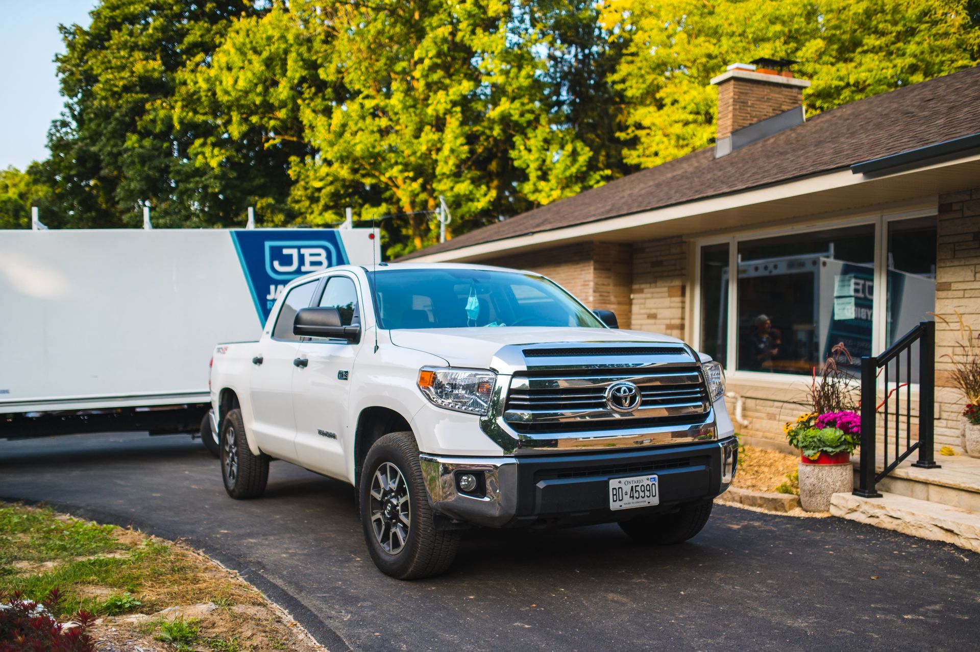 A white truck is parked in front of a house.