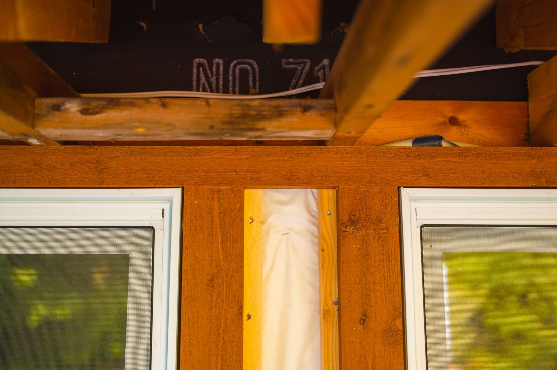 A close up of a wooden wall with three windows.