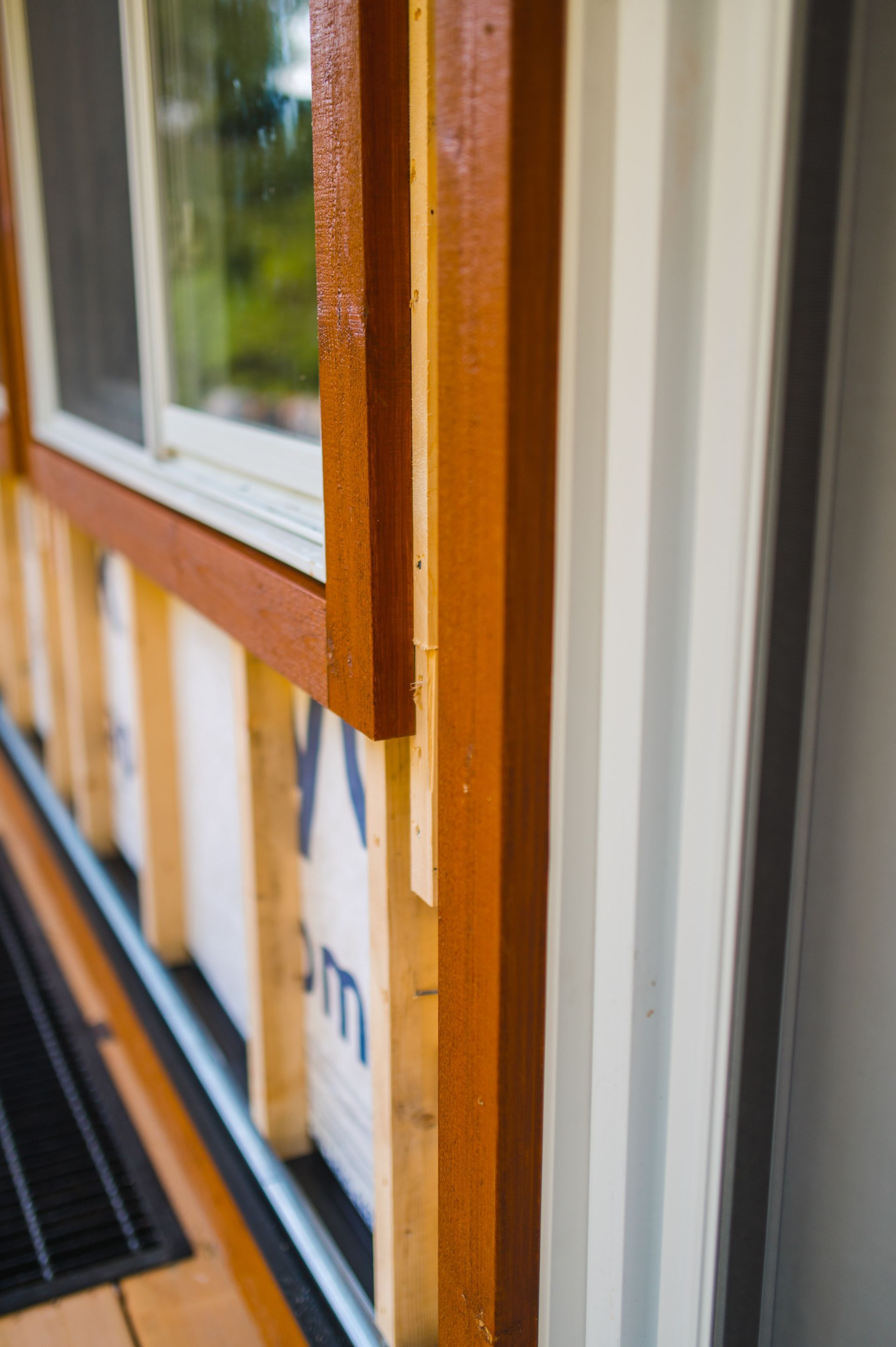 A close up of a window on a house with a wooden frame.