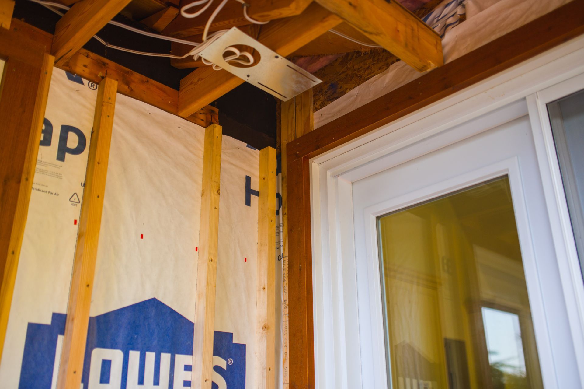 A sliding glass door is being installed in a house under construction.
