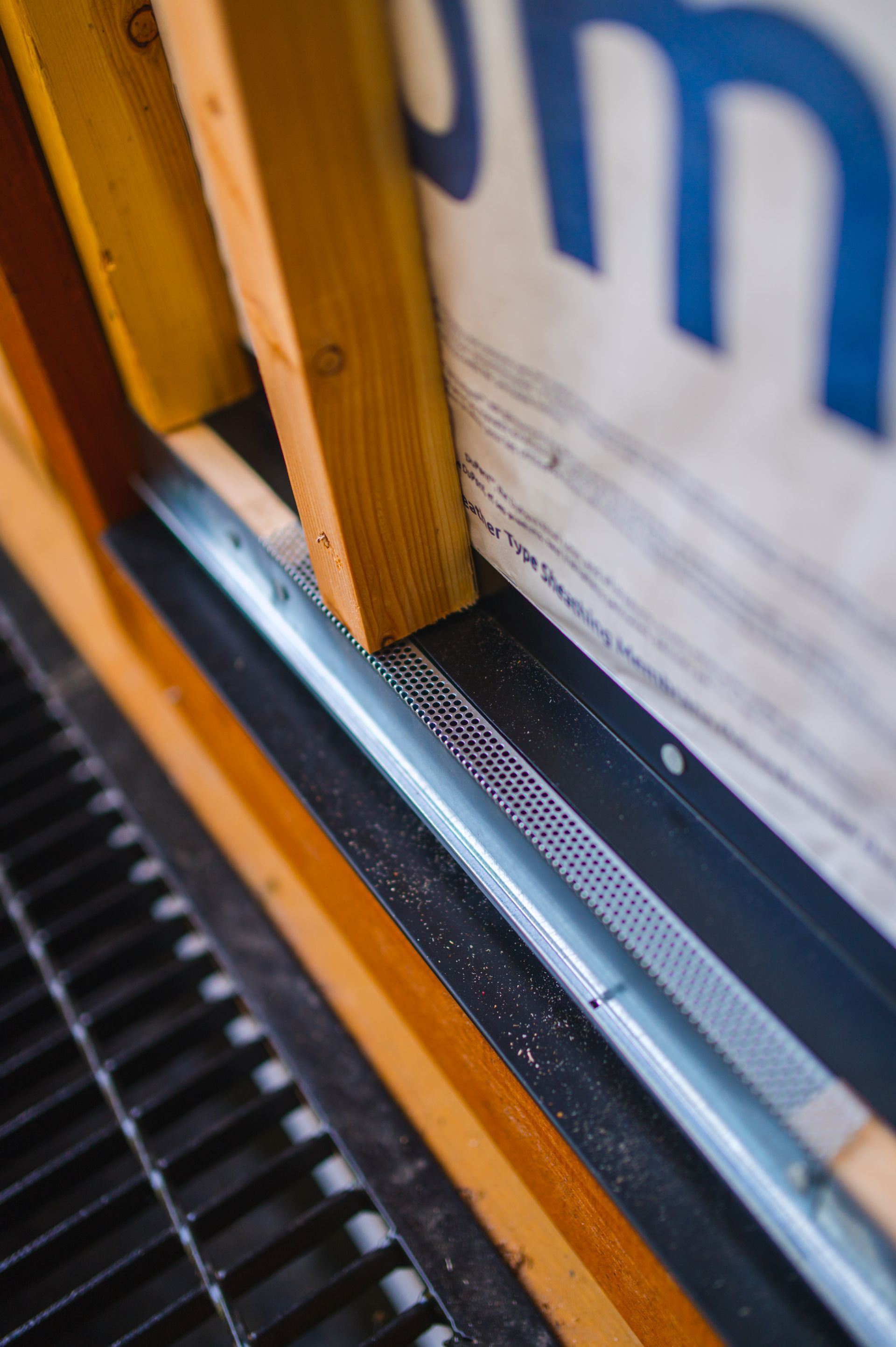 A close up of a window frame with a metal drain underneath it.