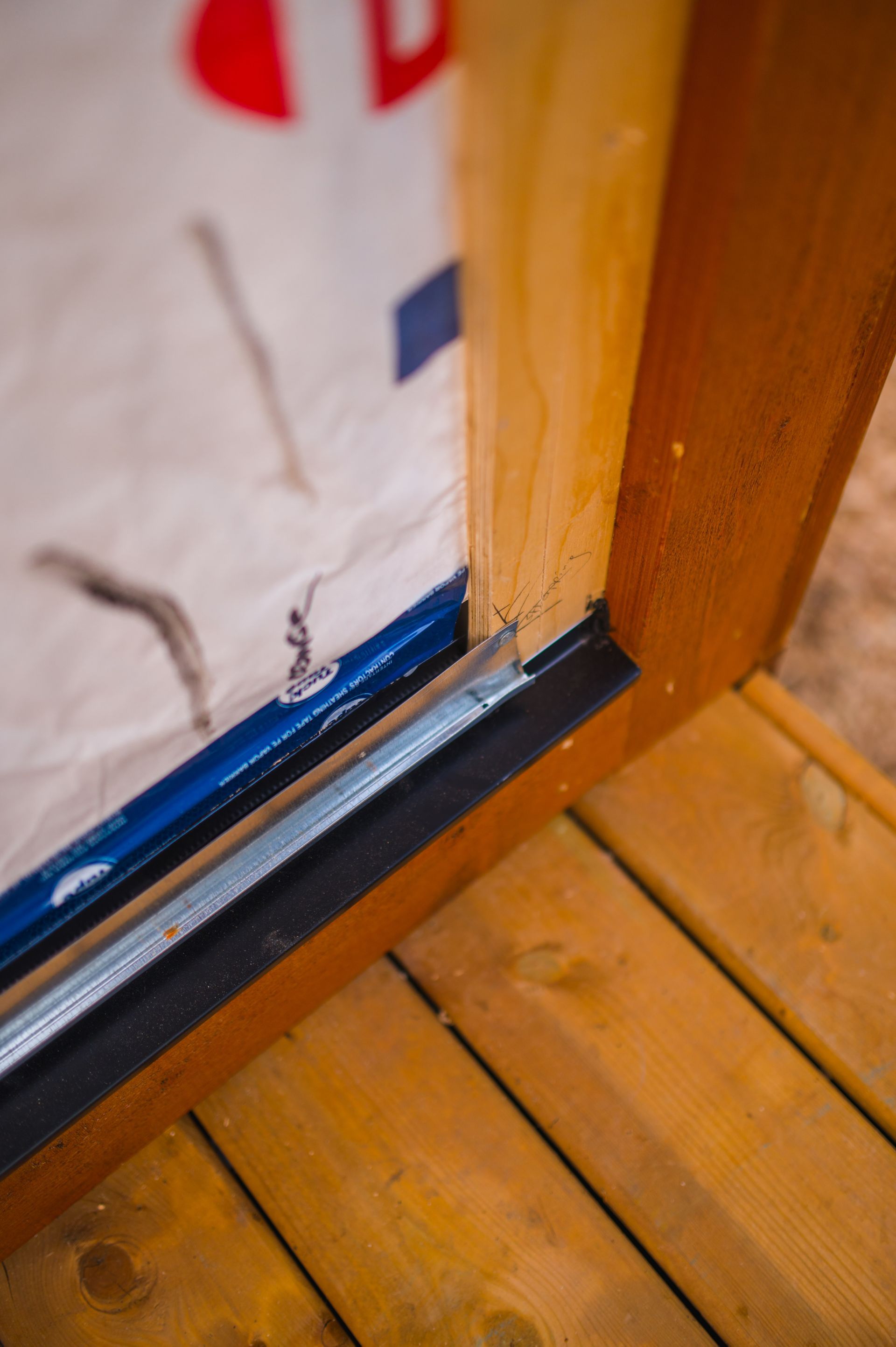 A close up of a wooden door on a wooden deck.