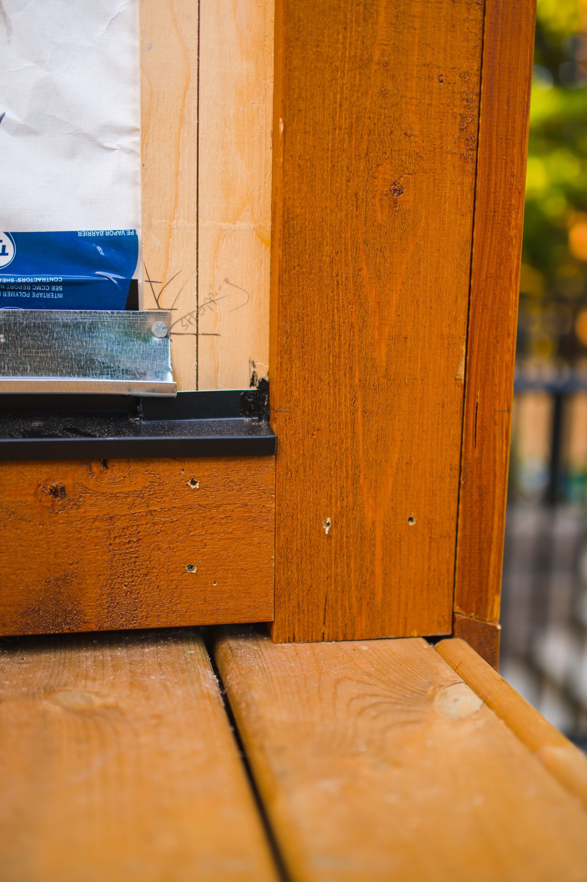 A close up of a wooden window frame on a wooden deck.