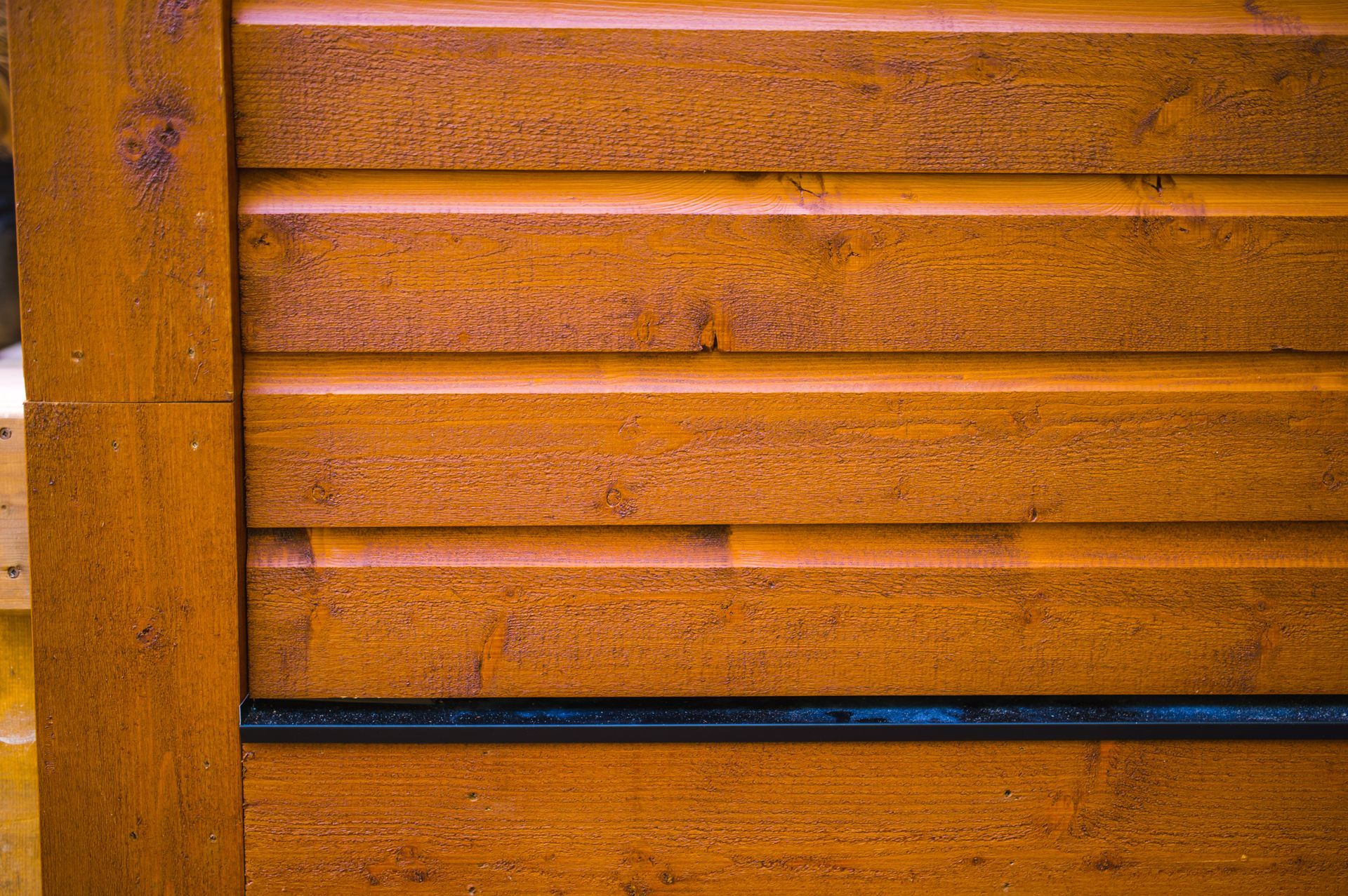 A close up of a wooden wall with a black trim.