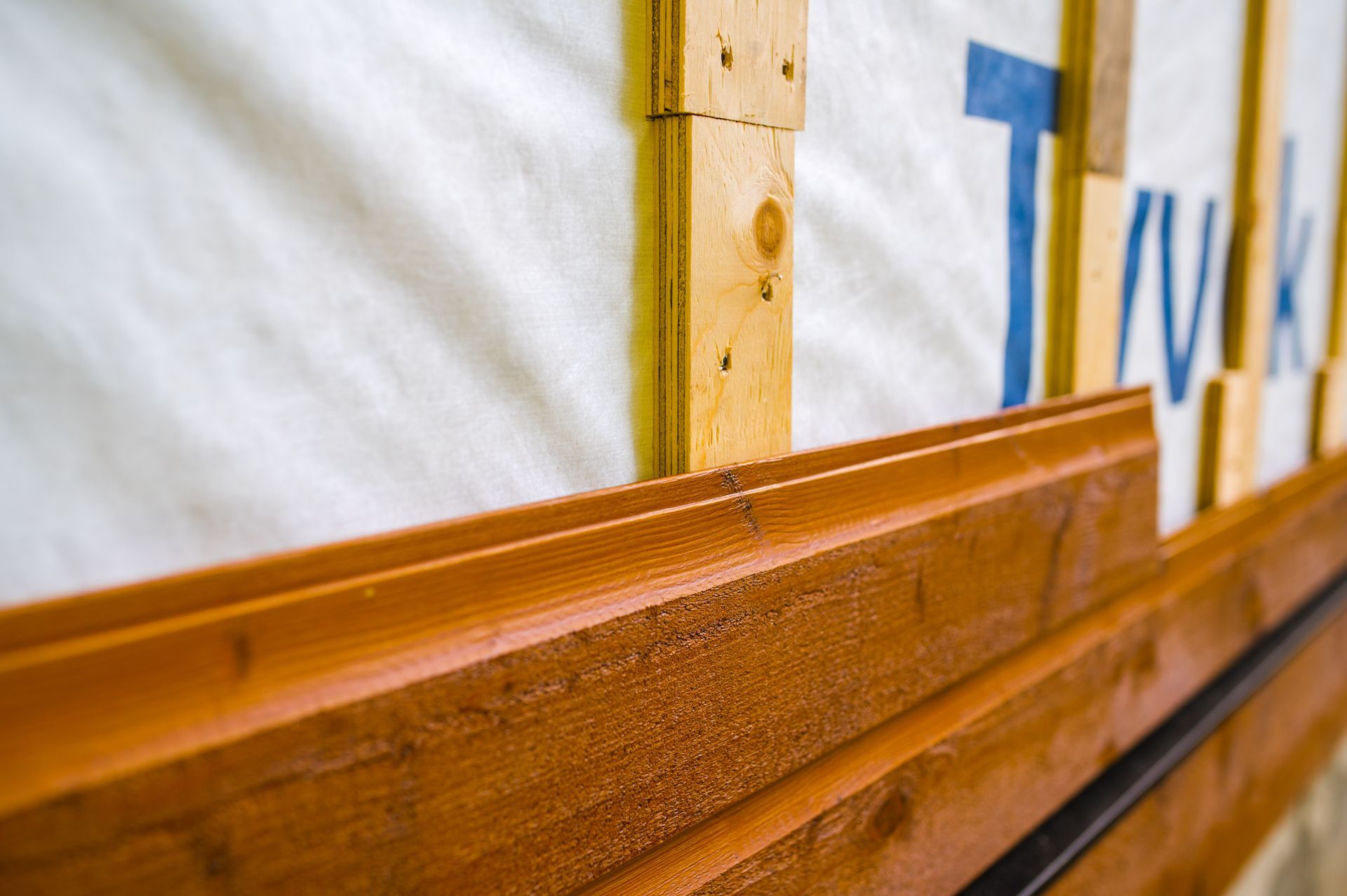 A close up of a wooden wall with a piece of tape on it.
