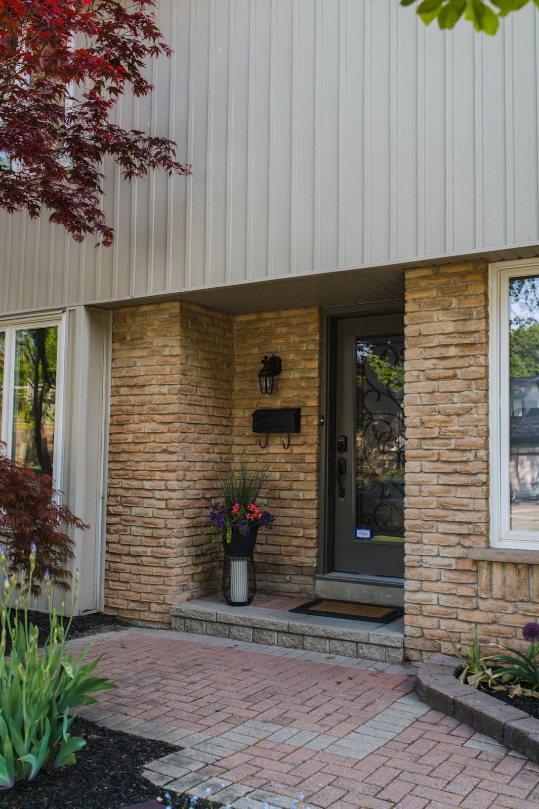 A brick house with a brick walkway leading to the front door.