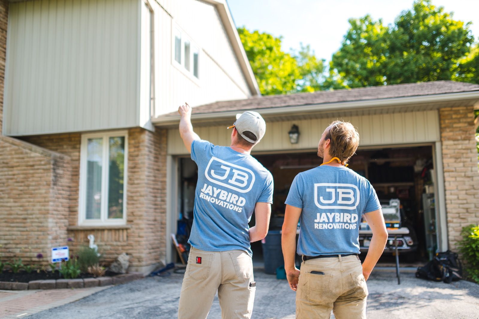 A man and a woman are standing in front of a house.
